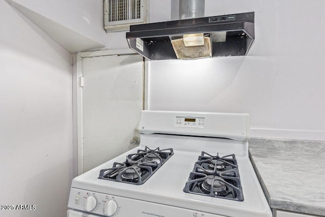 kitchen featuring visible vents, light countertops, under cabinet range hood, and gas range