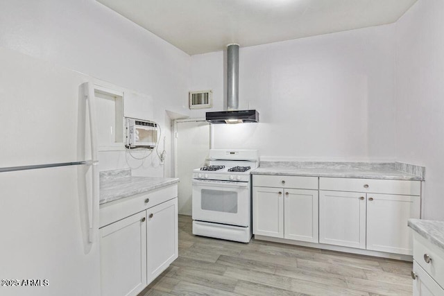 kitchen with light wood-type flooring, white appliances, visible vents, and white cabinets