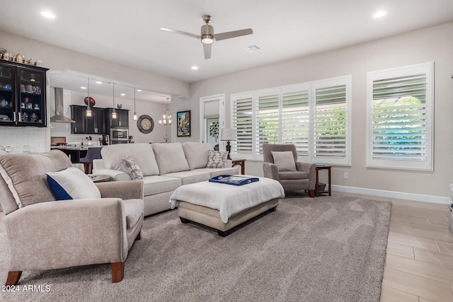 living room with light hardwood / wood-style floors and ceiling fan with notable chandelier