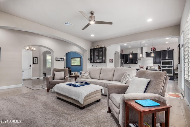 living room with ceiling fan with notable chandelier