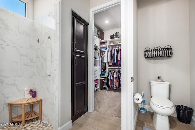 bathroom featuring a tile shower and toilet