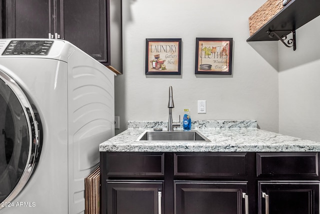 clothes washing area featuring cabinets and sink