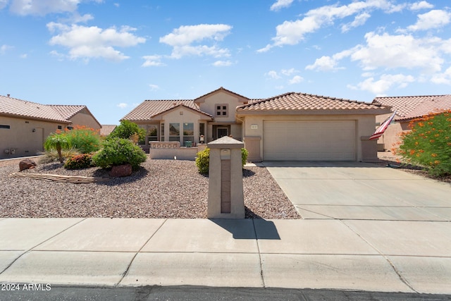 mediterranean / spanish home with driveway, a tiled roof, a garage, and stucco siding