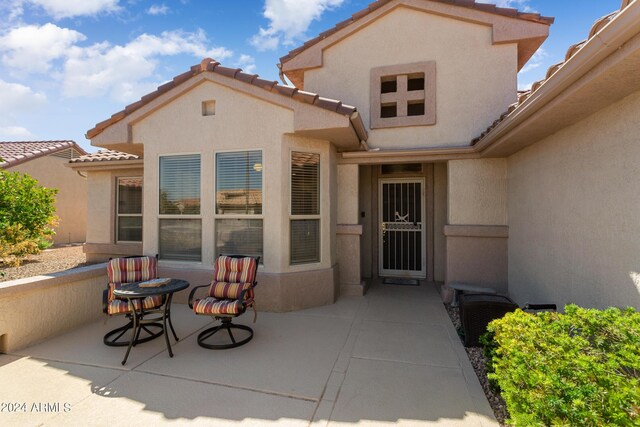 view of exterior entry featuring a patio