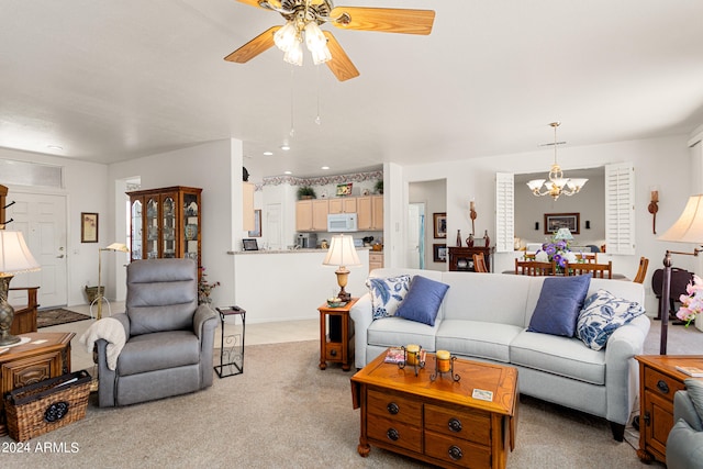 carpeted living room featuring ceiling fan with notable chandelier