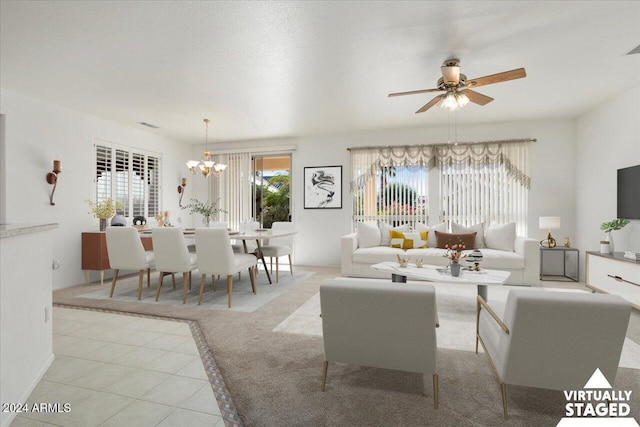 living area with tile patterned flooring and ceiling fan with notable chandelier