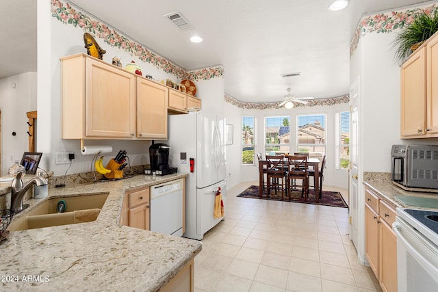 kitchen with white appliances, light brown cabinets, a sink, and visible vents