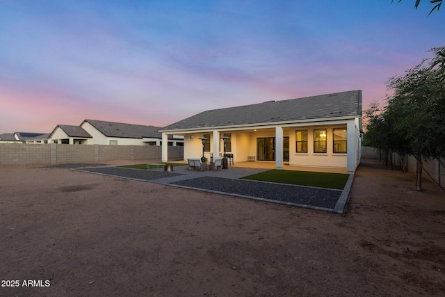 1294 E Ln Fortuna Ct, San Tan Valley, AZ 85140 - back of house at dusk with a patio area, a fenced backyard, and stucco siding