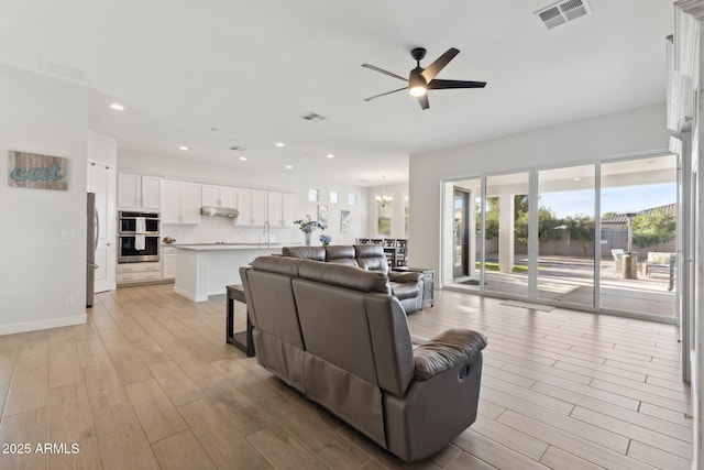 1294 E Ln Fortuna Ct, San Tan Valley, AZ 85140 - living area with light wood finished floors, ceiling fan, recessed lighting, and a chandelier