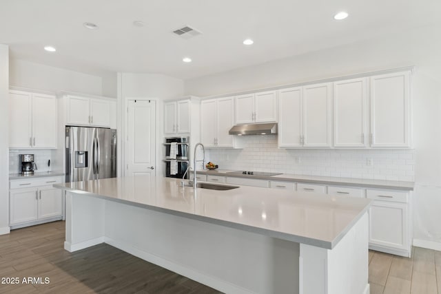 1294 E Ln Fortuna Ct, San Tan Valley, AZ 85140 - kitchen featuring stainless steel fridge, under cabinet range hood, decorative backsplash, white cabinets, and an island with sink
