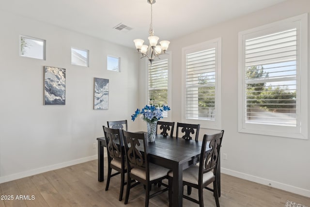 1294 E Ln Fortuna Ct, San Tan Valley, AZ 85140 - dining room with a chandelier, light wood-type flooring, and plenty of natural light