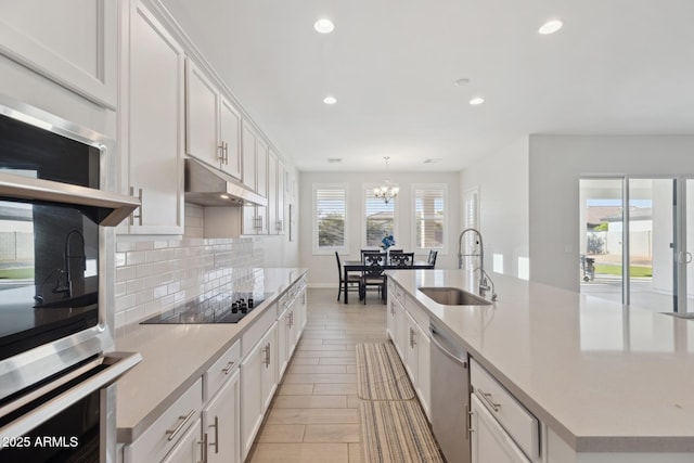 1294 E Ln Fortuna Ct, San Tan Valley, AZ 85140 - kitchen featuring appliances with stainless steel finishes, under cabinet range hood, a chandelier, tasteful backsplash, and white cabinets