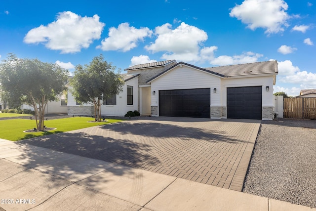 1294 E Ln Fortuna Ct, San Tan Valley, AZ 85140 - view of front of property with a garage, decorative driveway, solar panels, and stone siding