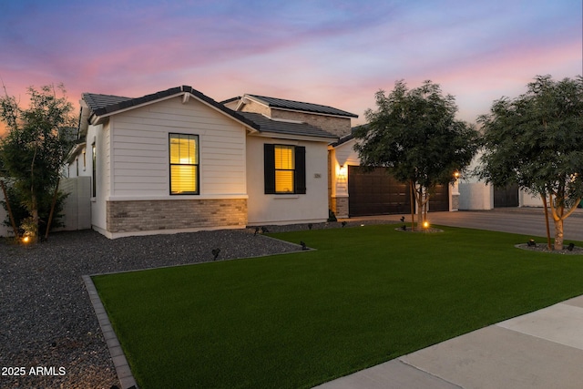1294 E Ln Fortuna Ct, San Tan Valley, AZ 85140 - view of front of property with concrete driveway, roof mounted solar panels, an attached garage, stone siding, and an outdoor fire pit