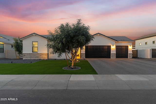 1294 E Ln Fortuna Ct, San Tan Valley, AZ 85140 - view of front of home featuring an attached garage, driveway, a front lawn, a tile roof, and stone siding