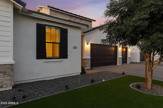 1294 E Ln Fortuna Ct, San Tan Valley, AZ 85140 - view of front of house with an attached garage, stone siding, concrete driveway, and a front lawn