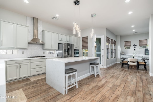 6621 S Balboa Dr, Gilbert, AZ 85298 - kitchen featuring wall chimney range hood, appliances with stainless steel finishes, a kitchen island, recessed lighting, and light countertops