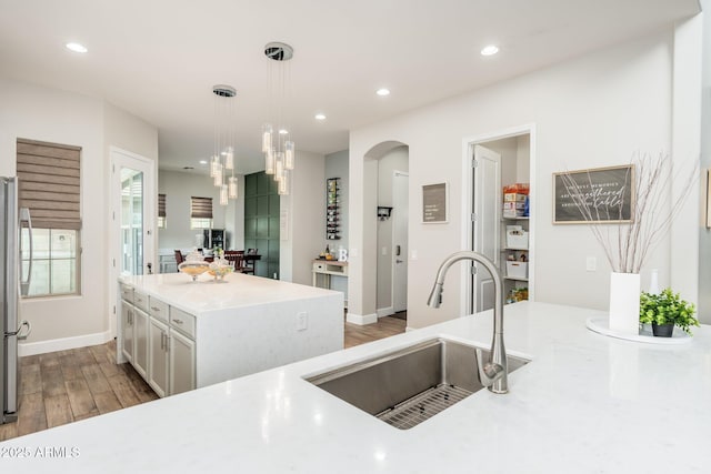 6621 S Balboa Dr, Gilbert, AZ 85298 - kitchen featuring a sink, arched walkways, light countertops, recessed lighting, and decorative light fixtures