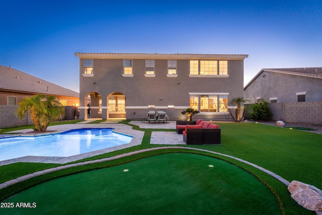 6621 S Balboa Dr, Gilbert, AZ 85298 - back of property at dusk with a putting green, a fenced backyard, a patio area, and stucco siding