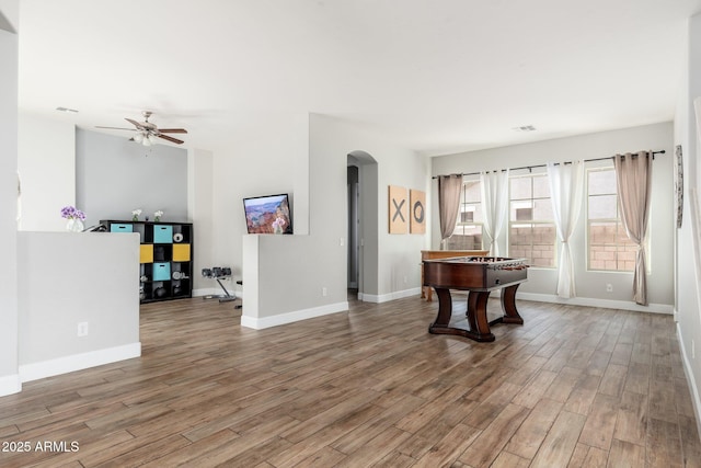 6621 S Balboa Dr, Gilbert, AZ 85298 - living room with arched walkways, wood finished floors, ceiling fan, and baseboards