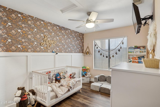 13320 N 82nd Dr, Peoria, AZ 85381 - bedroom with wallpapered walls, a nursery area, wood finished floors, wainscoting, and a ceiling fan