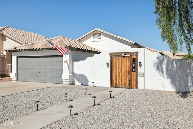13320 N 82nd Dr, Peoria, AZ 85381 - view of front of home with a garage, a gate, driveway, stucco siding, and a tiled roof