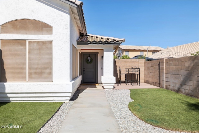 13320 N 82nd Dr, Peoria, AZ 85381 - doorway to property featuring stucco siding, fence, a tiled roof, and a patio area