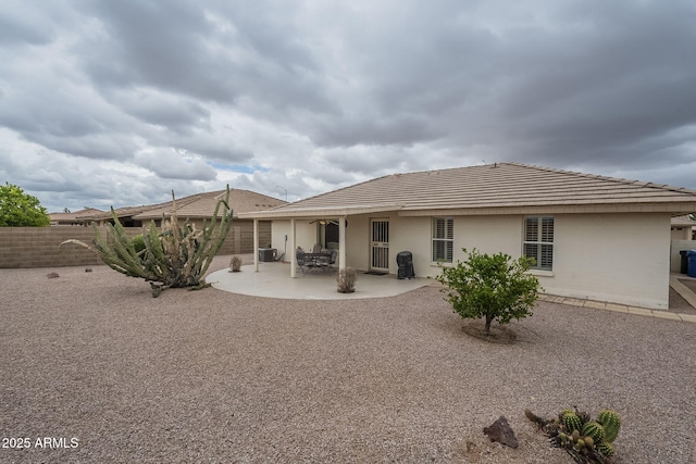 rear view of property featuring fence, a patio, and stucco siding