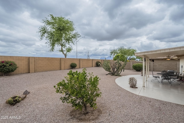 view of yard with central air condition unit, a patio area, ceiling fan, and a fenced backyard