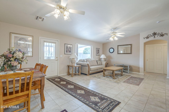 living area featuring baseboards, a ceiling fan, light tile patterned floors, and visible vents