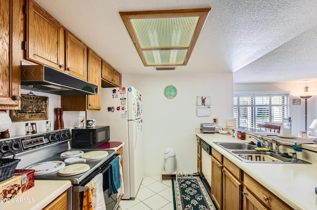 kitchen with dishwasher, sink, range with electric stovetop, light tile patterned floors, and a textured ceiling