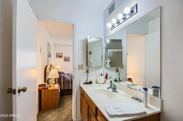 bathroom featuring vanity and a shower with shower door