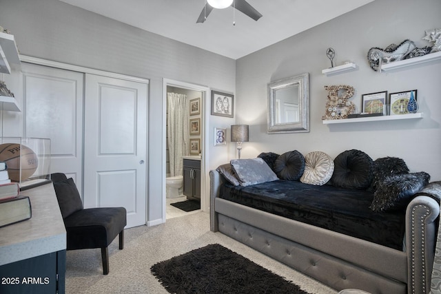 bedroom with ceiling fan, ensuite bathroom, a closet, and light colored carpet