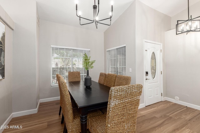 1114 N Leland Ct, Gilbert, AZ 85233 - dining area with a chandelier, light wood finished floors, baseboards, and a towering ceiling