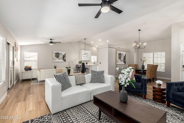 1114 N Leland Ct, Gilbert, AZ 85233 - living area with ceiling fan, lofted ceiling, a chandelier, light wood-style floors, and baseboards