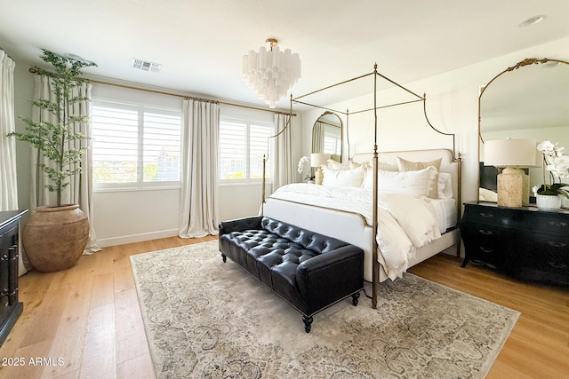 bedroom featuring wood finished floors, baseboards, and a chandelier