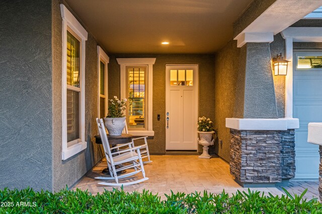 property entrance with stucco siding and stone siding
