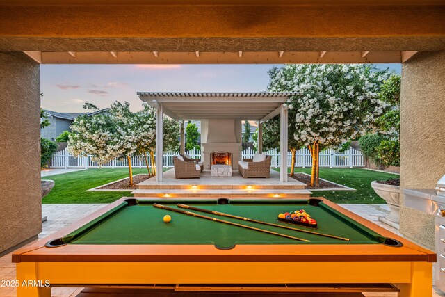 game room with pool table, a lit fireplace, and beam ceiling
