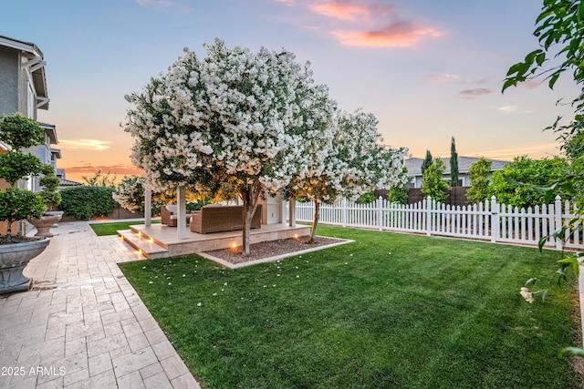 yard at dusk with a patio and an outdoor living space
