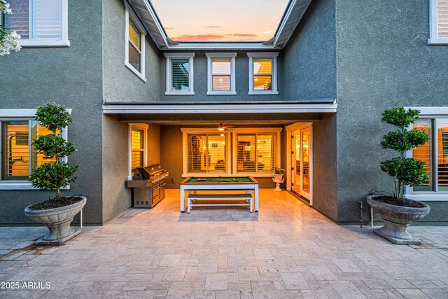 property entrance with stucco siding and a patio area