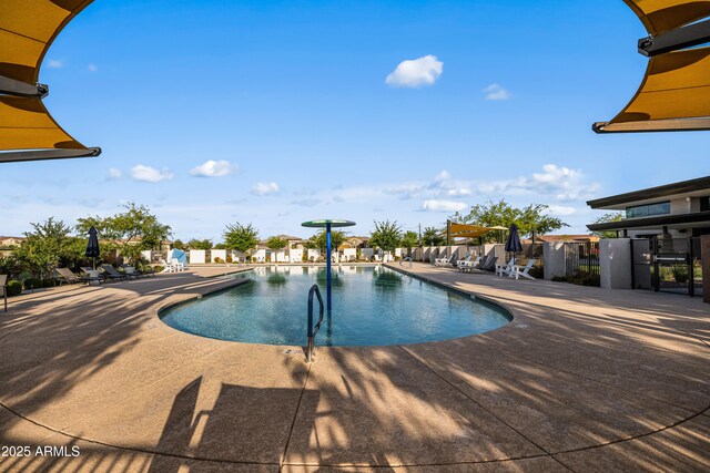 community pool with a patio and a residential view