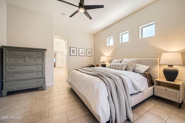 bedroom featuring a ceiling fan, arched walkways, and connected bathroom