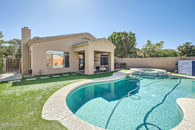 view of swimming pool featuring a yard, a pool with connected hot tub, a patio, and fence