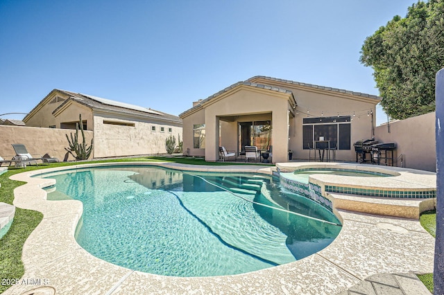 view of swimming pool featuring a pool with connected hot tub, fence, and a patio