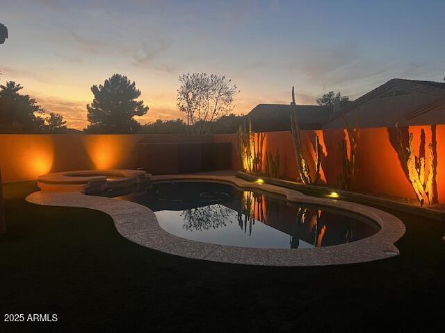 view of pool featuring a fenced backyard and a pool with connected hot tub