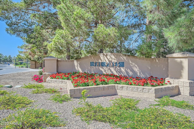 community / neighborhood sign featuring fence