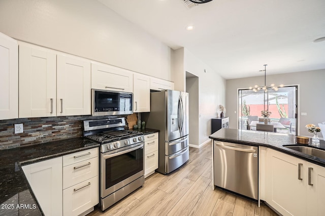 kitchen with tasteful backsplash, appliances with stainless steel finishes, light wood-style floors, white cabinetry, and a sink