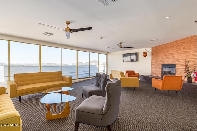 living room featuring floor to ceiling windows, carpet flooring, and ceiling fan