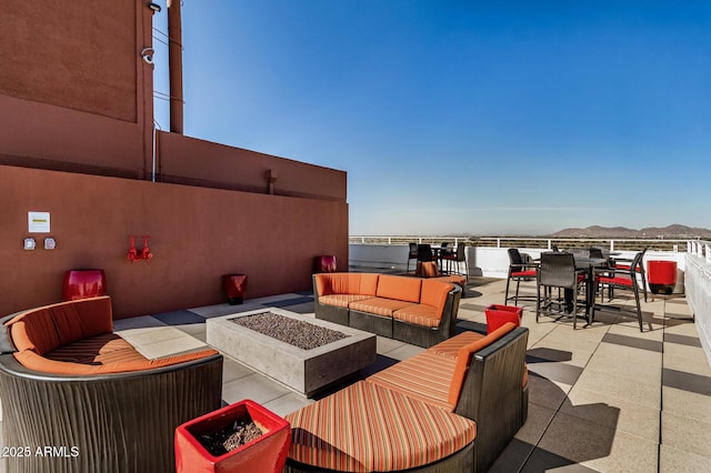 view of patio / terrace with a mountain view and an outdoor living space with a fire pit