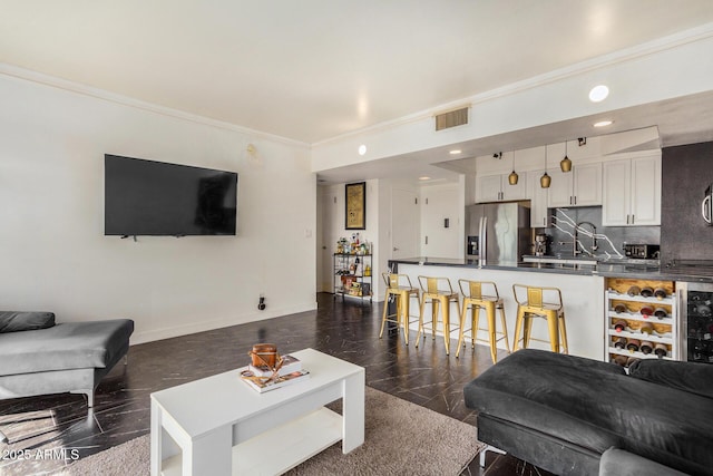 living room with sink and ornamental molding